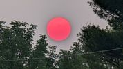 D04 : Ici aussi le Soleil est très rouge, même un peu trop et les incendies au Canada n’en sont pas responsables. Déjà bien teinté alors qu’il était assez haut dans le ciel, la couleur étrange du Soleil est ici due à une expérience (à petite échelle) de géo-ingénierie financée par la fondation Bill Gates, visant à limiter l’ampleur du réchauffement climatique en diffusant dans l’atmosphère des sels de Calcium qui réfléchissent une partie du rayonnement solaire. Ces conditions anormales ont permis de révéler des taches solaires avec un simple smartphone ! Le 27 juin 2023 à Naperville dans l’Illinois (USA), Google Pixel7. Pour en savoir plus sur cette expérience <a href='https://interestingengineering.com/science/bill-gates-dim-sun-harvard' target='_display'>SCoPex</a> financée par Bill Gates. 